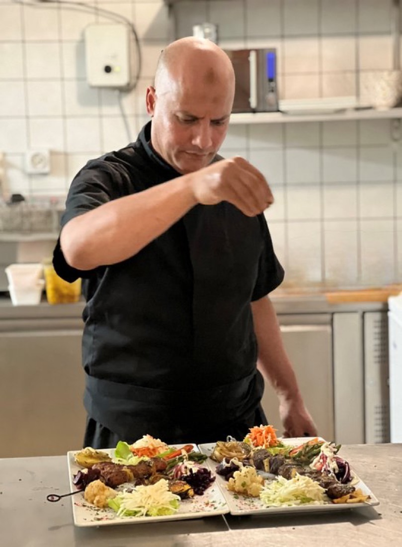 Chef richt met zorg een Marokkaans gerecht aan in de keuken van Tafilalet